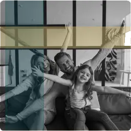 Family of three laughing together on a sofa