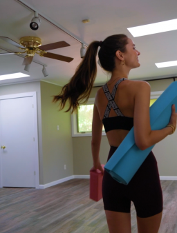 Yoga studio; guest carrying mat into sun-lit space